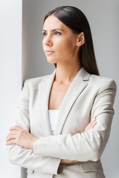 Thinking about business. Confident young businesswoman in suit keeping arms crossed and looking away photo