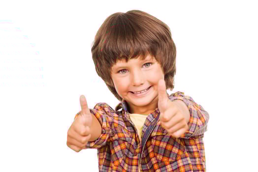 Thumbs up Happy little boy showing his thumbs up and smiling while standing isolated on white photo
