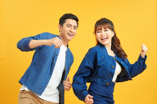 Beautiful young couple dancing on yellow background photo