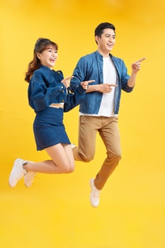 Full length body size view of his he her she nice attractive crazy funky cheerful couple jumping in air having fun fooling rejoicing isolated on yellow photo