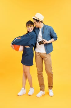 Attractive asian couple in casual outfit with digital camera  go to the beach photo