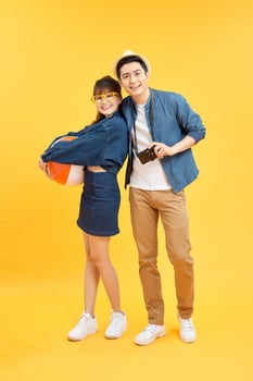 Playful Asian couple in summer casual clothes with beach accessories studio shot isolated photo