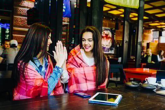 Two young and beautiful girls having fun in cafe photo
