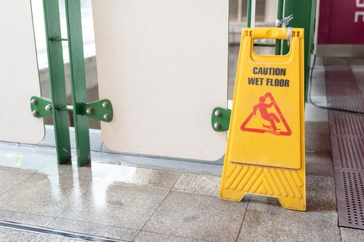 Yellow Caution slippery wet floor sign on the wet ground photo