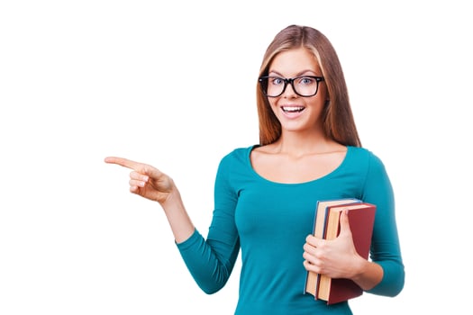 It is interesting. Beautiful young women looking at camera and pointing away while standing against white background. photo