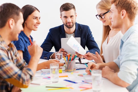 Working as team. Three confident business people in smart casual wear working together while sitting at the table photo