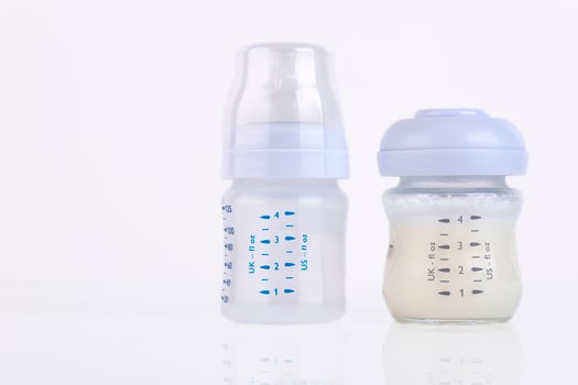 Baby bottle with pacifier and milk for feeding milk on a light background. Copy space. photo