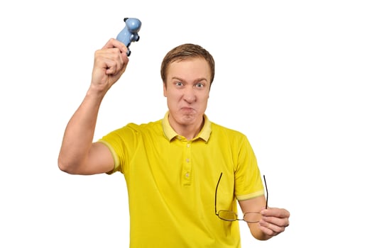 Angry gamer with wireless gamepad dressed in yellow T-shirt isolated on white background photo