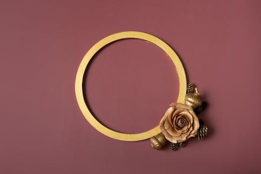 Golden ring and golden rose on a brown background. Flat lay, top view, copy space photo