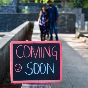 Indian couple posing for maternity baby shoot. The couple is posing in a lawn with green grass and the woman is falunting her baby bump in Lodhi Garden in New Delhi, India photo