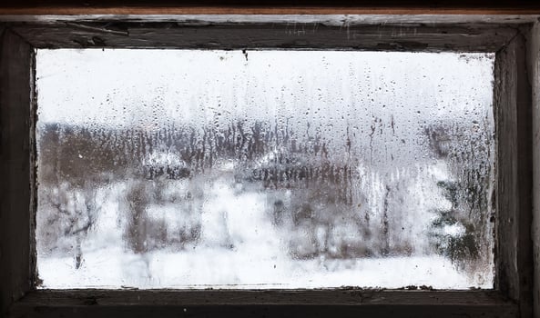 water drops from melting snow on frozen window photo