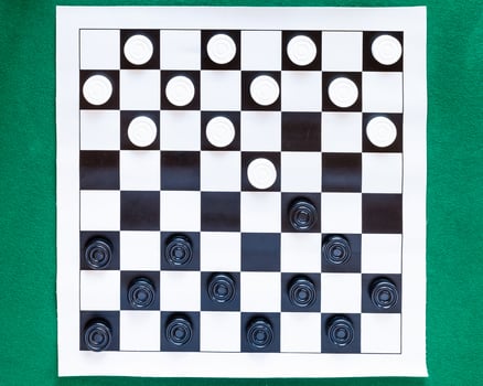 top view of checkers on black and white sheet photo