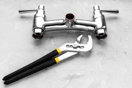 wrench near disassembled shower faucet valve photo