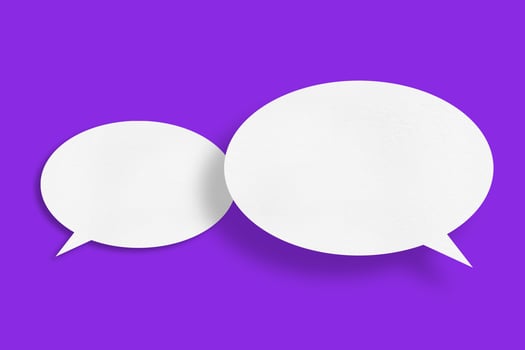 White paper in the shape of speech bubbles against a purple background. communication bubbles photo