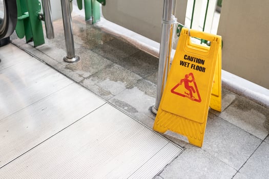 Yellow Caution slippery wet floor sign on the wet ground photo