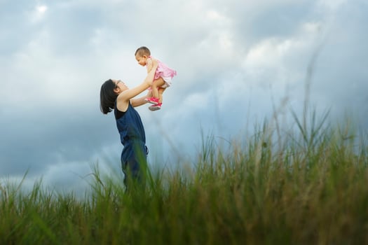 Mother and new born playing on the garden at the sunset time. Concept of friendly family - Vibrant color effect photo