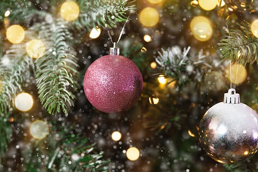Classic Christmas New Year decorated New year tree with pink and white ornament decorations toy and ball, snow and defocused garland lights. Modern classical holiday design. Christmas eve at home. photo