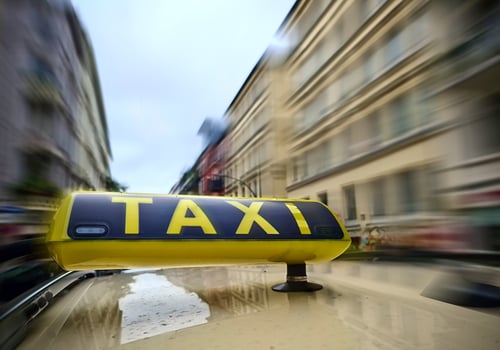 A taxi sign on a car with a lot of motion blur on the city background due to high speed. photo