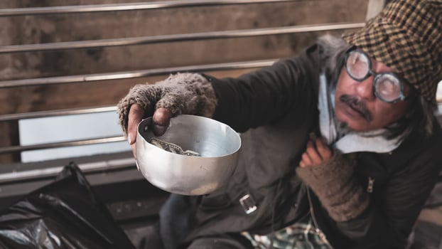 Homeless man sitting and begging for money. photo