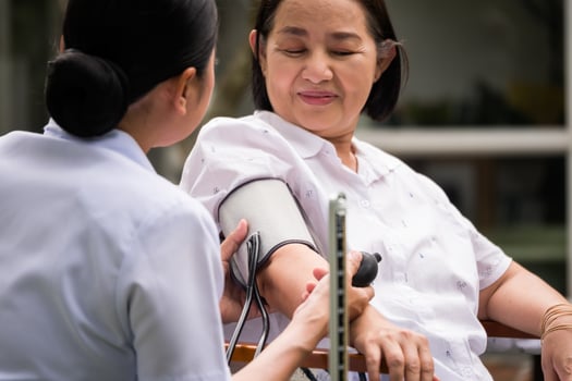 Nurse doing pressure measuring for female patient at the hospital park. photo