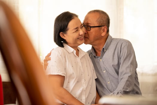 Asian husband kissing on his wife cheek. photo