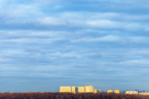 dark blue clouds over big apartment house and park photo