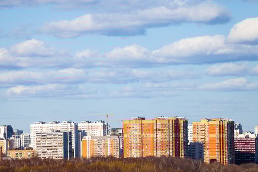 blue sky with clouds over urban multistorey houses photo
