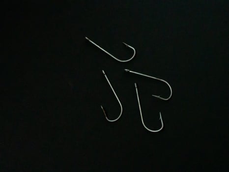 Large fishing hooks on a black background photo