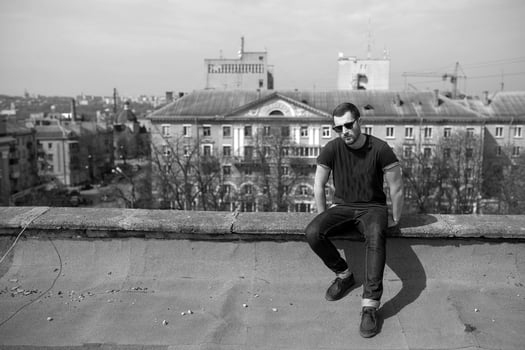 The man in the authentic boots and jeans selvedge on the roof of the building in the old town photo