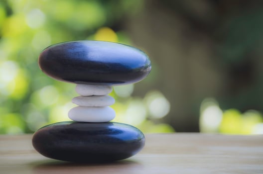 Spa black and white stone stack on wooden table, concept of balance and harmony. photo