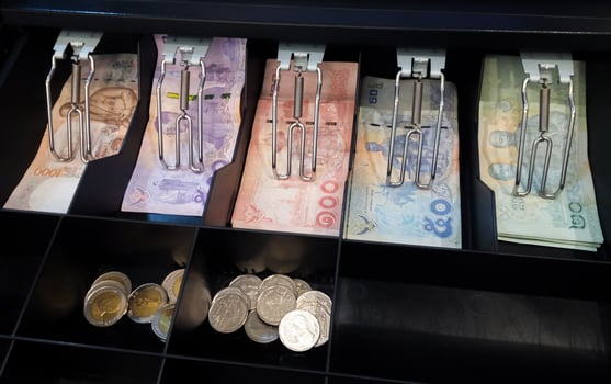 Thai bank notes and coins are in the cashier machine photo