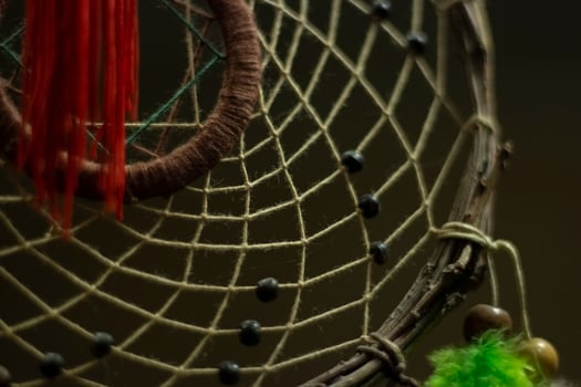 Dreamcatcher in interior. Details of Indian amulet for good sleep. Object woven from threads. Symbol of peace in house. photo