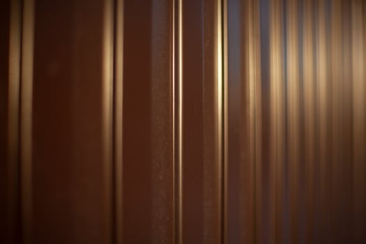 Texture of steel fence. Profile sheet is brown. Fence details. photo