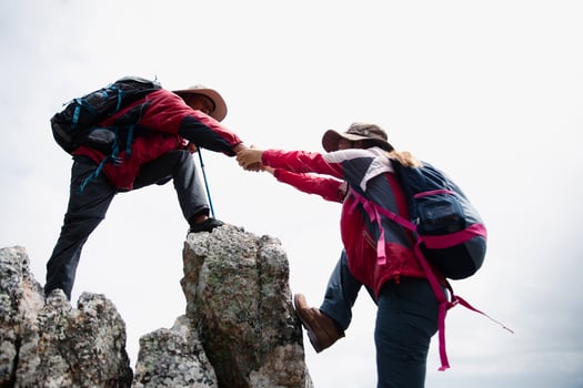 Person hike friends helping each other up a mountain. Man and woman giving a helping hand and active fit lifestyle. Asia couple hiking help each other. concept of friendship, teamwork. photo