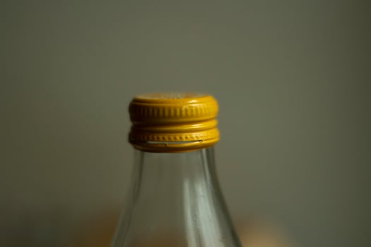 Yellow lid on a glass bottle. Glass water bottle. photo