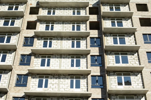 New building. Construction of an apartment building in Moscow. Residential house in sunlight. Inserted plastic windows in the house. photo