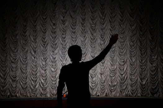 Silhouette of the director. A man directs a play. Hand gesture. photo
