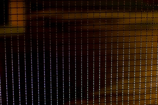 Metal mesh in the dark. The texture of the grille at night. Fence made of steel. photo