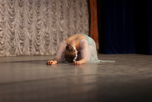 The girl lies on the stage. The ballerina performs. Beautiful movements of the dancer. photo
