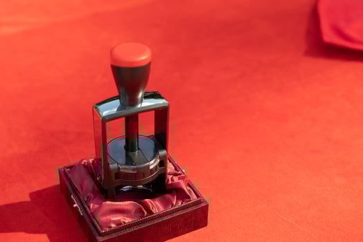 Seal for solemn signing by document. A red tablecloth on the table and an item for stamping envelopes. The predominance of red. photo