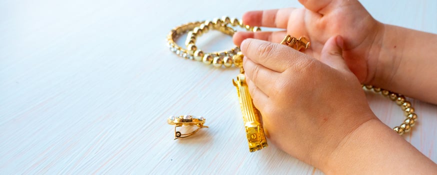 childrens hands play with gold jewelry and bijouterie, on white background. concept of womens happines photo
