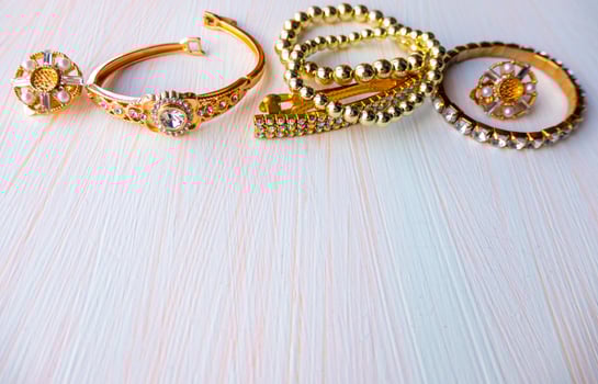 a lot of gold costume jewelry with different materials on a white background. Copy space photo