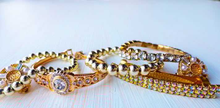 a lot of gold costume jewelry with different materials on a white background photo