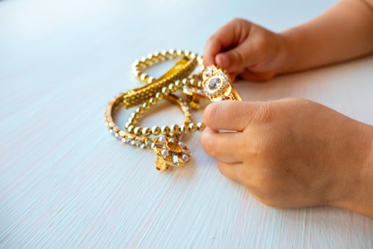 childrens hands play with gold jewelry and bijouterie, on white background. concept of womens happines photo