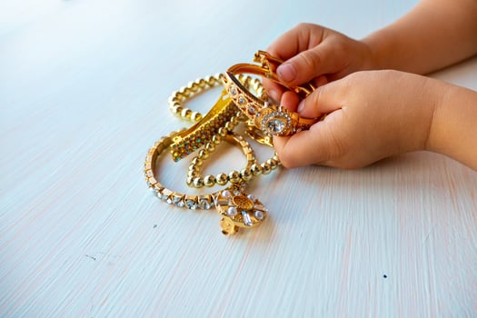 childrens hands play with gold jewelry and bijouterie, on white background. concept of womens happines photo