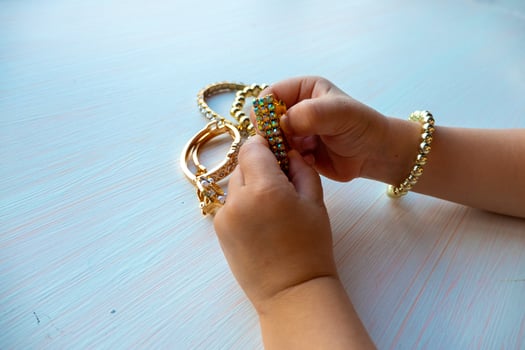 childrens hands play with gold jewelry and bijouterie, on white background. concept of womens happines photo
