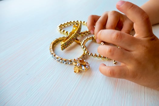 childrens hands play with gold jewelry and bijouterie, on white background. concept of womens happines photo