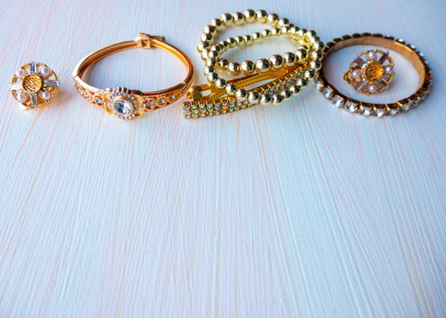 a lot of gold costume jewelry with different materials on a white background. Copy space photo