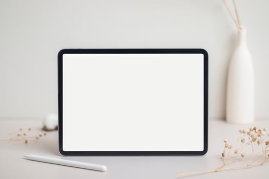Tablet empty white screen with pencil mock-up. Cotton flower and dry leaves on beige background mockup for design photo