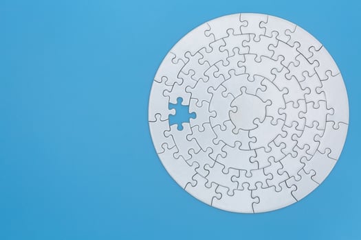 Unfinished white jigsaw puzzle pieces on blue background, The last missing piece of the jigsaw puzzle. photo
